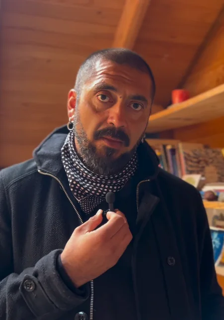 Vicente Larenas Añasco, retrato con pañuelo al cuello en una cabaña de madera